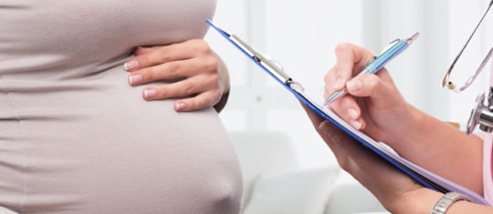 photo d'une sage-femme qui examine une femme enceinte